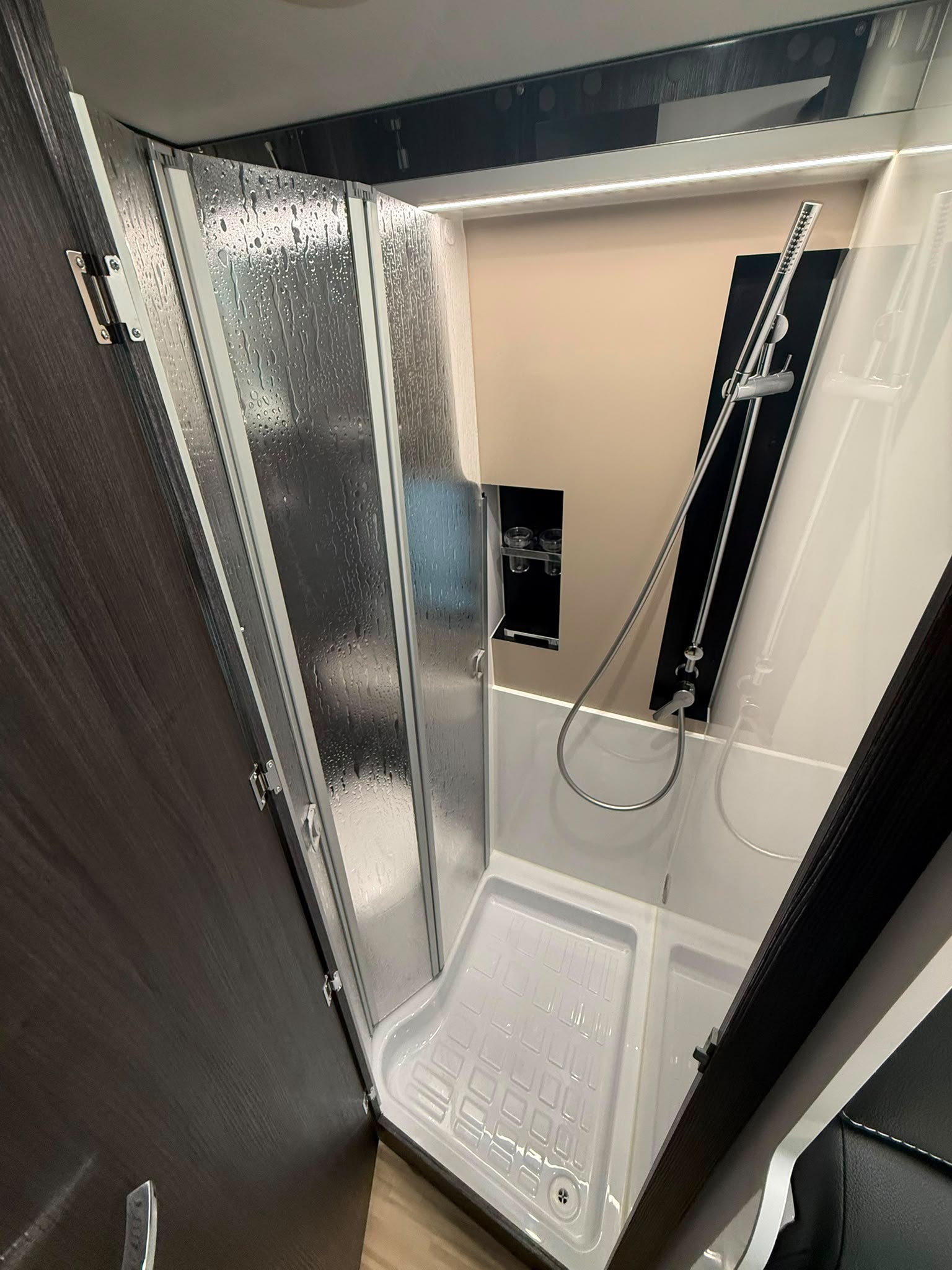 Ducha con mampara y acabados premium en camper